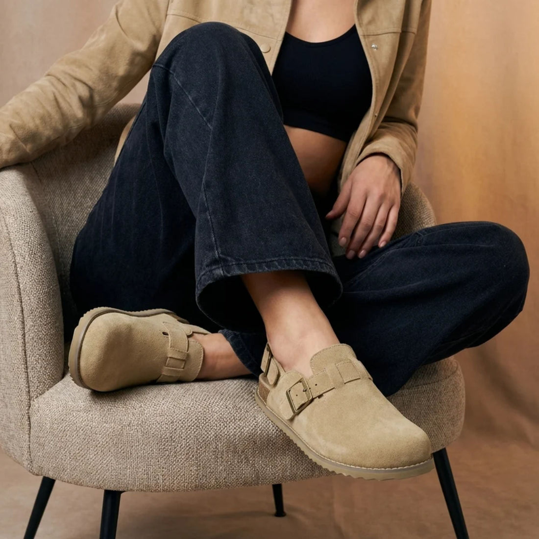Stugan® clogs i Biskvi, burna av någon som sitter i en fåtölj
